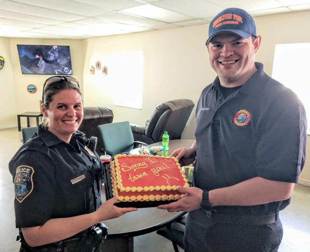 Hamilton Township Police Officer Darcy Workman says she accidentally tasered firefighter Rickey Wagoner and gave him a cake to apologise.
