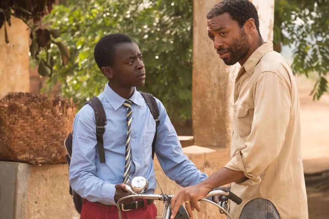 William Kamkwamba (Maxwell Simba) and his father Trywell (Chiwetel Ejiofor) and the bike that will prove important later on in The Boy Who Harnessed the Wind.