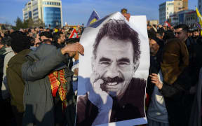 Supporters display a poster depicting jailed leader of the Kurdistan Workers' Party (PKK) Abdullah Ocalan, 75, after he called on the Kurdistan Workers' Party (PKK) to disarm and dissolve itself in Diyarbakir, southeastern Turkey. (Photo by Yasin AKGUL / AFP)
