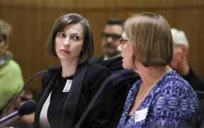 Lizzie Armstrong listens to her colleague Sally Stewart briefing a Select Committee for the Ministry of Health