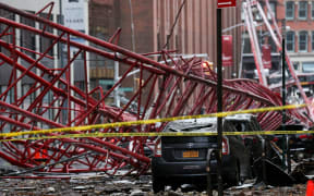 One person, who was sitting in a parked car, was killed when the crane crashed down on top of them.