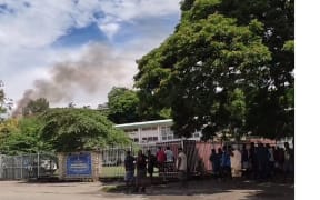 Smoke rising from a hut in the Solomon Islands parliament grounds after the protests.