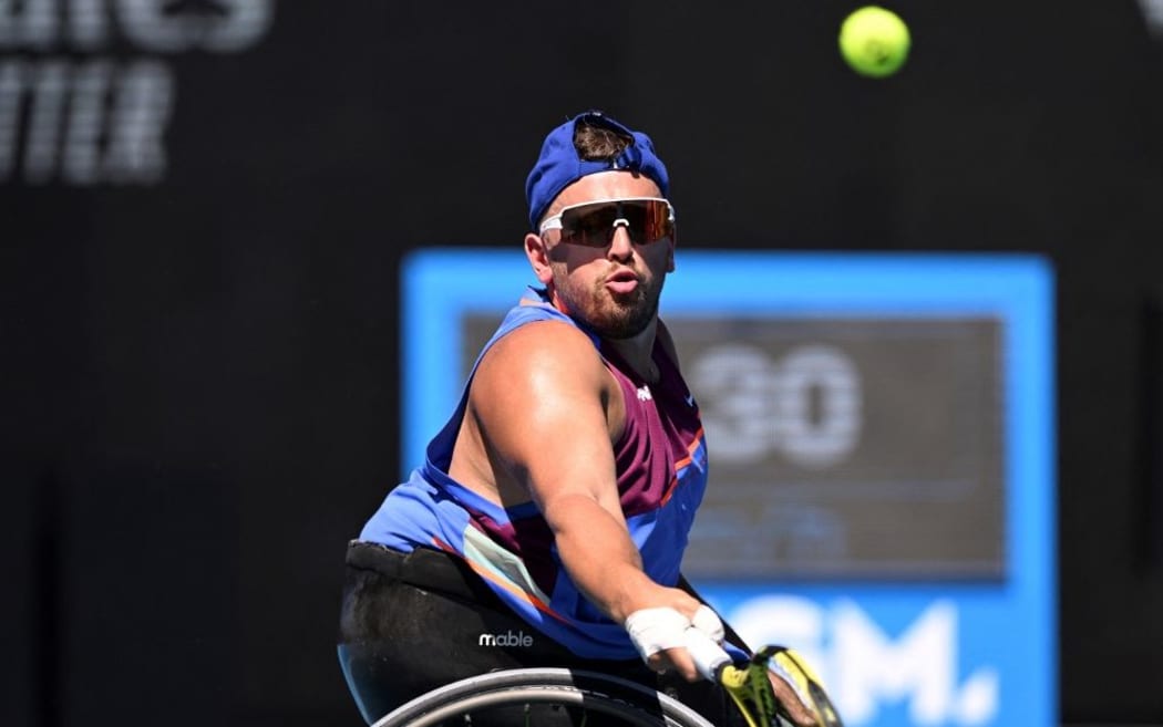 Australia's Dylan Alcott hits a return against Britain's Andy Lapthorne during their men's quad wheelchair singles semi-finals match Australian Open tennis tournament in Melbourne on January 25, 2022.