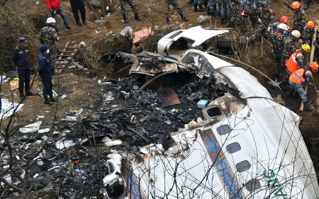 EDITORS NOTE: Graphic content / Rescuers pull the body of a victim who died in a Yeti Airlines plane crash in Pokhara on January 16, 2023. - Nepal observed a day of mourning on January 16 for the victims of the nation's deadliest aviation disaster in three decades, with 67 people confirmed killed in the plane crash. (Photo by PRAKASH MATHEMA / AFP)