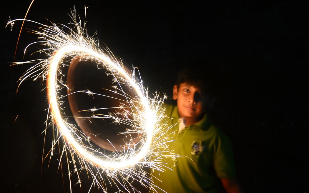 A Sri Lankan boy celebrates new year with a sparkler in Colombo.