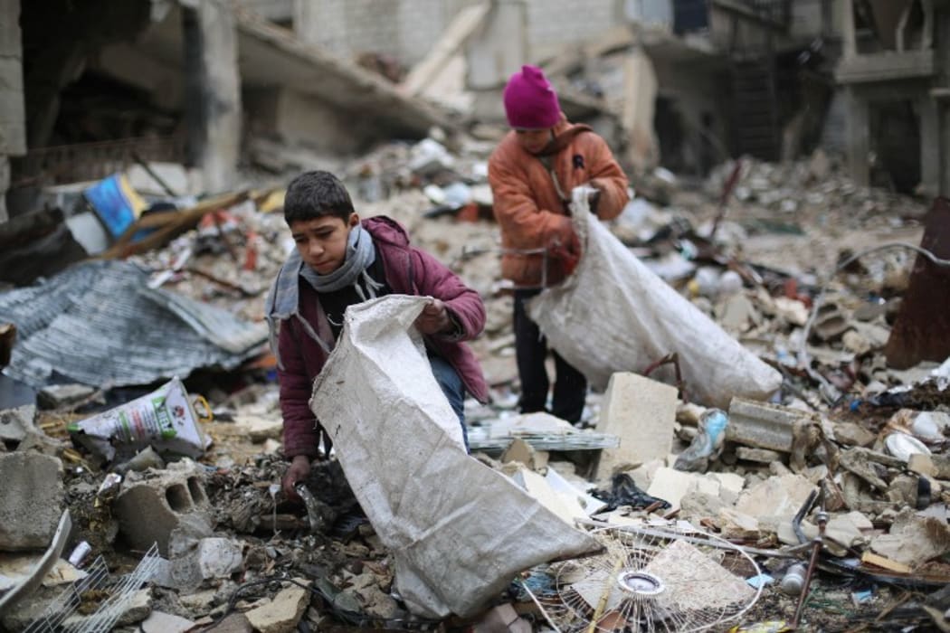 Syrian youths collect wood from rubble in Damascus to use for heating and cooking.