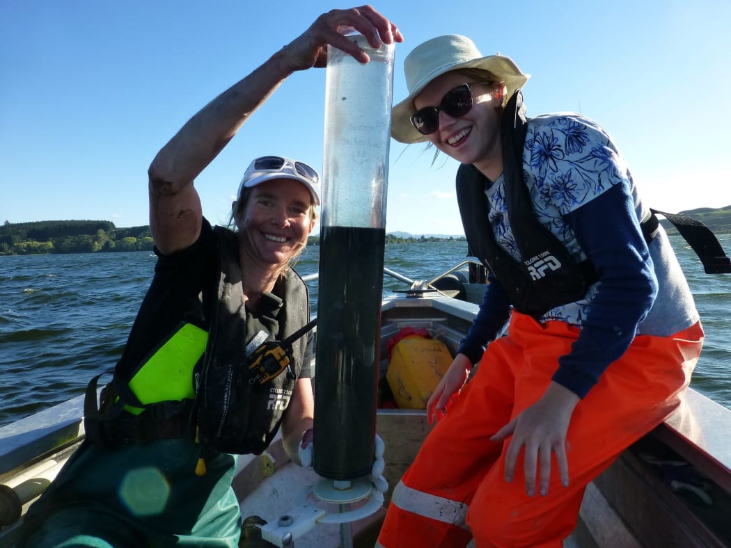 Susie Wood and Julia Short showing the muddy side of sediment coring, at Lake Rotoiti, near Rotorua.
