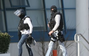 Armed French policemen wearing bulletproof jacket walk at the Tocqueville high school in the southern French town of Grasse, on March 16, 2017