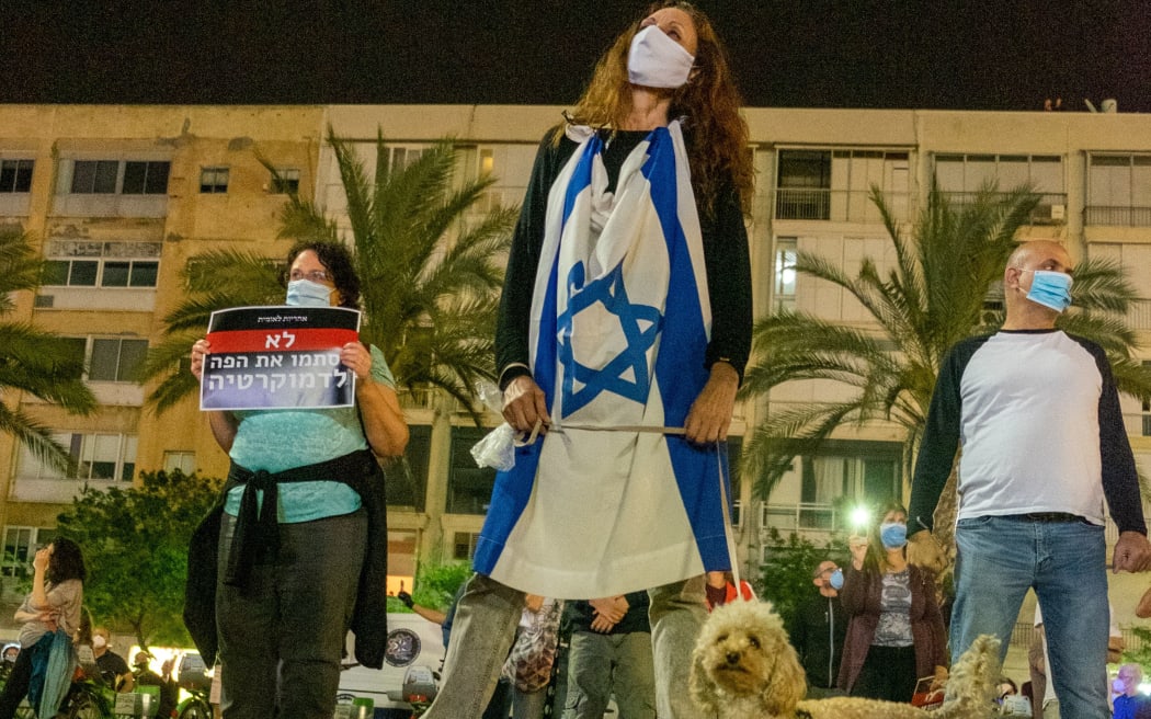 TEL AVIV, ISRAEL - APRIL 19: Israelis, wearing protective face masks due to the novel coronavirus (COVID-19) pandemic and keeping social distance, gather to protest against Prime Minister Benjamin Netanyahu at Rabin Square in Tel Aviv, Israel on April 19, 2020.