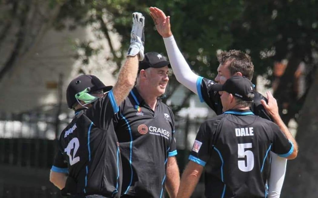 Stephen Hewson celebrates with teammates after taking a wicket in the over 50s Cricket World Cup in Cape Town, South Africa.