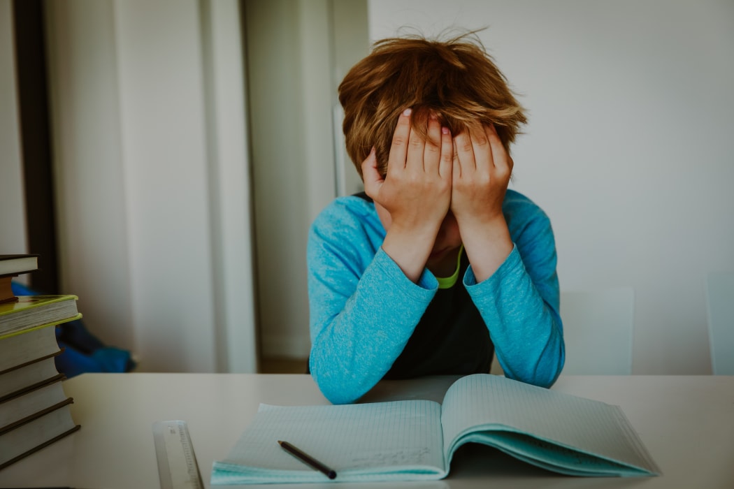 Child crying, tired of doing homework, overload, depressed. (file photo)