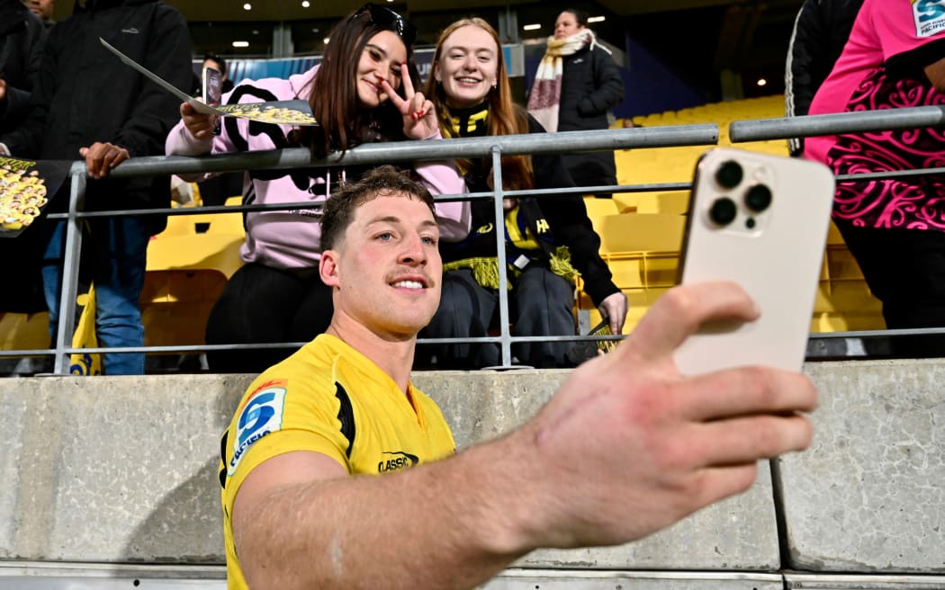 Riley Higgins of the Hurricanes poses for a photo with fans.