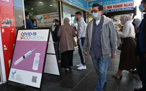 Residents queue up outside a pharmacy for a Covid-19 vaccination in western Sydney on July 30, 2021. (Photo by Saeed KHAN / AFP)