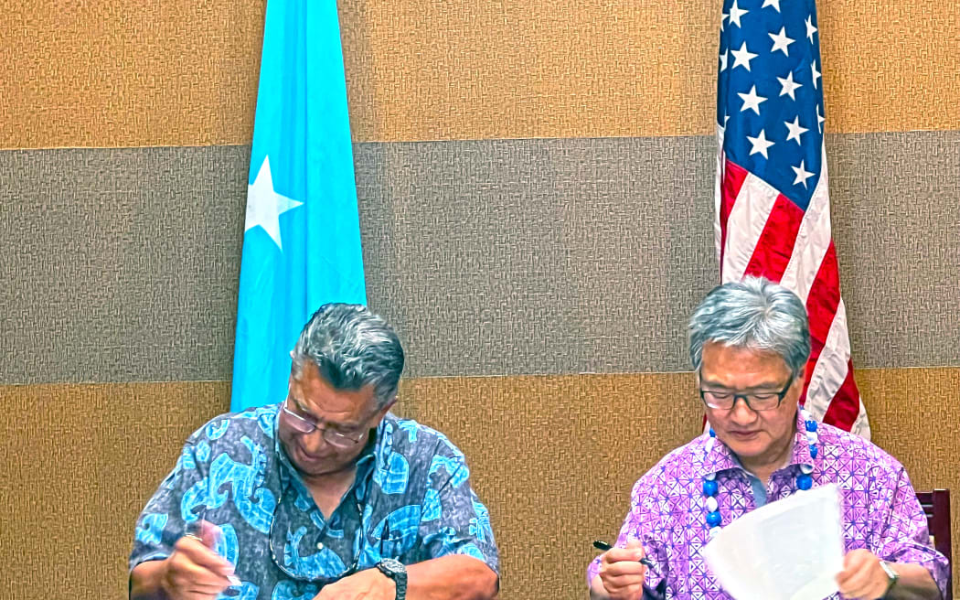 FSM Chief Negotiator Leo A. Falcam, Jr., left, joins with Special Presidential Envoy Joseph Yun on Monday this week in Pohnpei to initial a nearly final version of the new 20-year funding agreement for extending the Compact of Free Association.