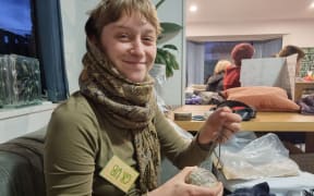 Grub McMasters is repairing a hole in a rug as part of Repair Revolution