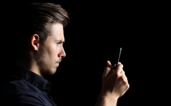 Angry teenager texting on smart phone.