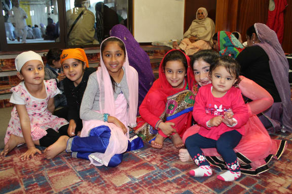 Sikh children wait outside the prayer area