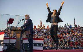 Tesla CEO Elon Musk (R) jumps on stage as he joins former US President and Republican presidential candidate Donald Trump during a campaign rally at site of his first assassination attempt in Butler, Pennsylvania on October 5, 2024. (Photo by Jim WATSON / AFP)