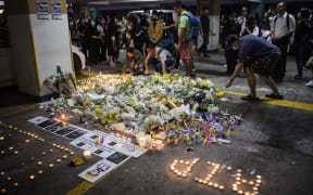 Mourners place flowers and candles as they pay their respects at the car park where student Alex Chow, 22, fell during a recent protest in the Tseung Kwan O area on the Kowloon side of Hong Kong on November 8, 2019.