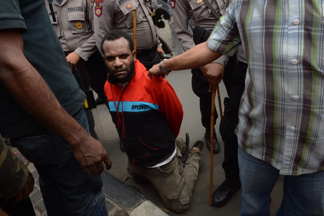 A Papuan pro-independence demonstrator is arrested by police in Jakarta on December 1, 2015 after police fired tear gas at a hundreds-strong crowd hurling rocks during a protest against Indonesian rule over the eastern region of Papua.