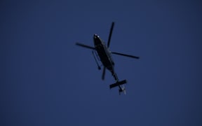 A police Eagle helicopter over the scene in Massey, Auckland.