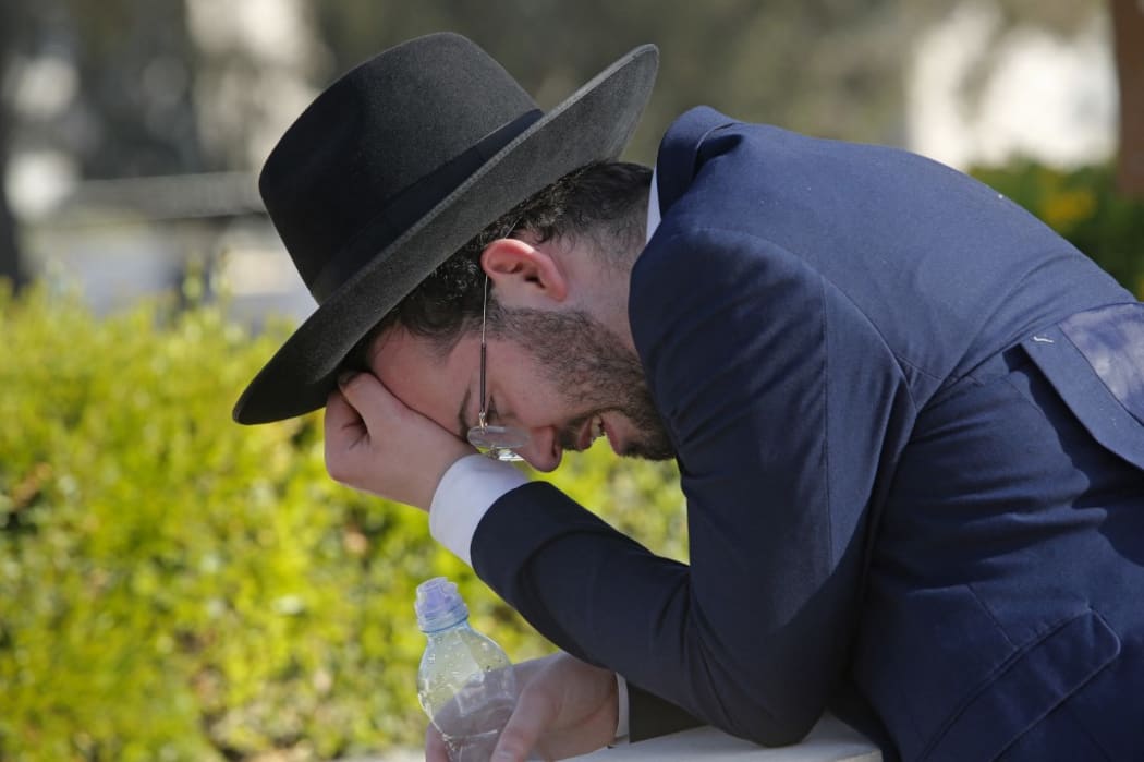 An Ultra-Orthodox Jew mourns at Segula cemetery in Petah Tikva during the funeral of a victim of Jewish pilgrim stampede, on April 30, 2021.