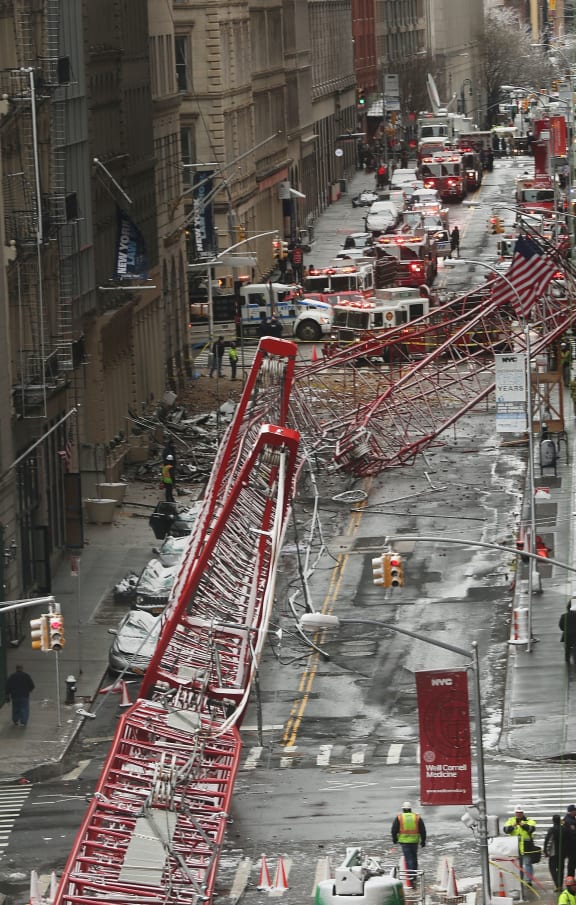 Emergency workers converge at the scene of a collapsed crane in a roadway in lower Manhattan.