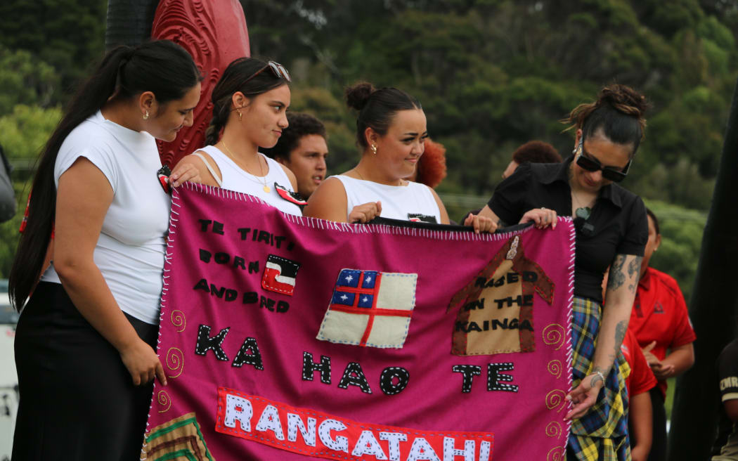 Three kōtiro gift rangatahi MP Tamatha Paul a paraikete (blanket) inscribed with the kupu ‘Ka hao te rangatahi’ – a message that the next generation will take up the work and responsibility.