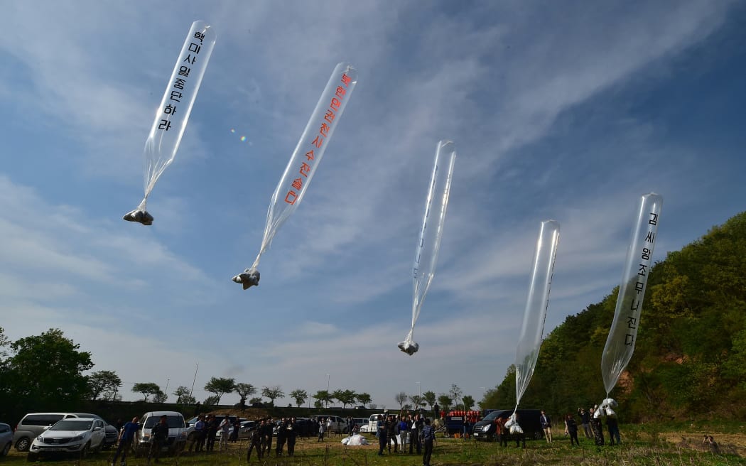 South Korean and US activists release balloons carrying anti-Pyongyang leaflets at a field near the Demilitarized zone dividing the two Koreas in the border city of Paju on 29 April, 2016.
