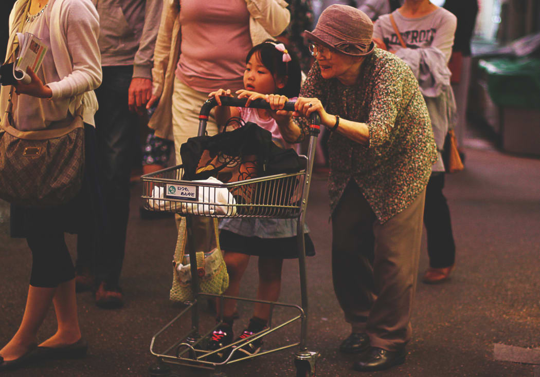 A photo of an elderly woman in Japan with a young child.