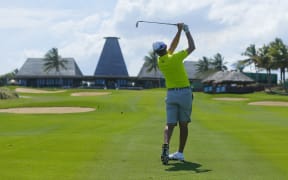 Mike Weir gets in some practice on the 18th hole, with the clubhouse in the distance.