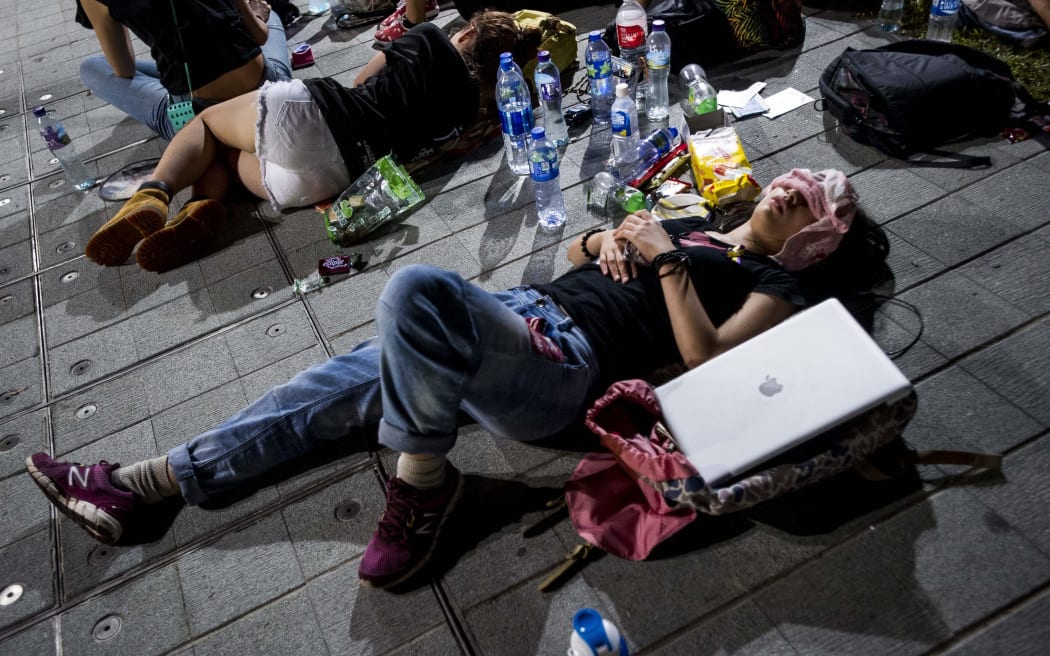 Pro-democracy protesters rest outside outside government offices in Hong Kong
