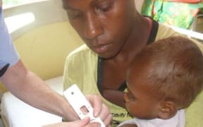 A baby goes through a common manutrition screening at Lenakel Hospital.