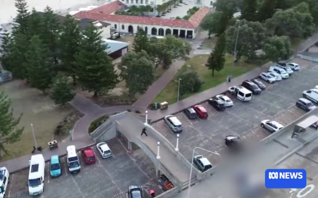 Drone camera video shows a shooter on a footbridge at Bondi Beach.