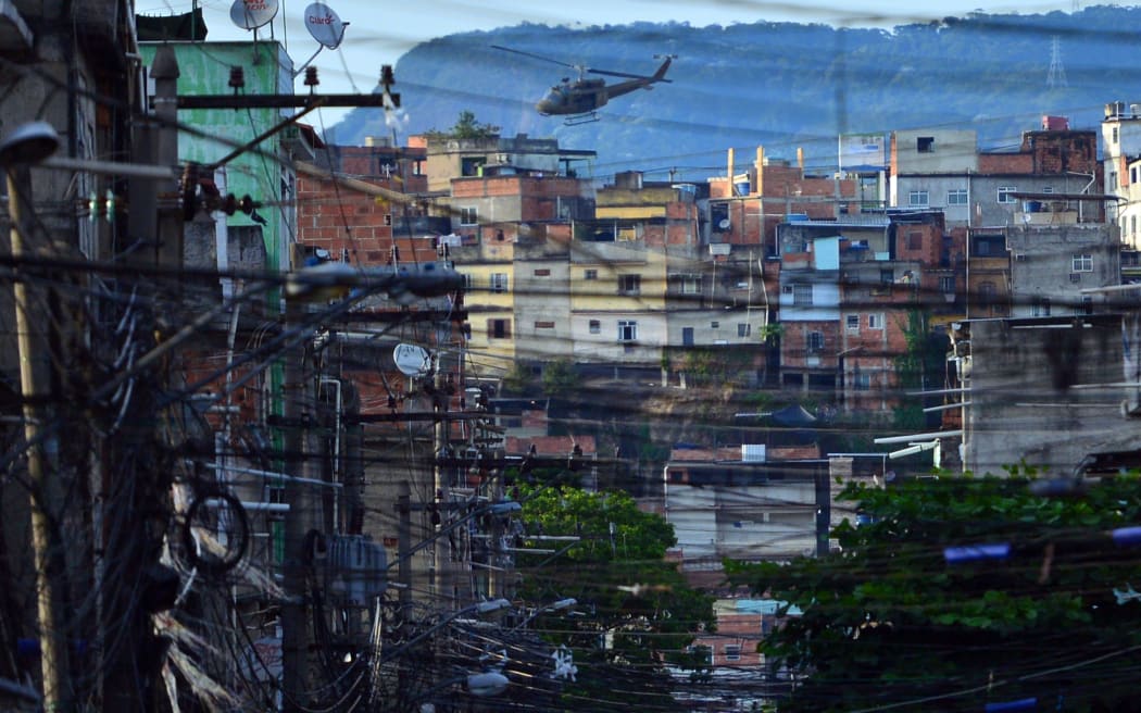 A paramilitary police helicopter flying over the Favela da Mare complex in Rio de Janeiro.