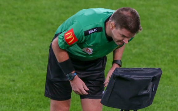 Referee Adam Kersey looks at VAR monitor.