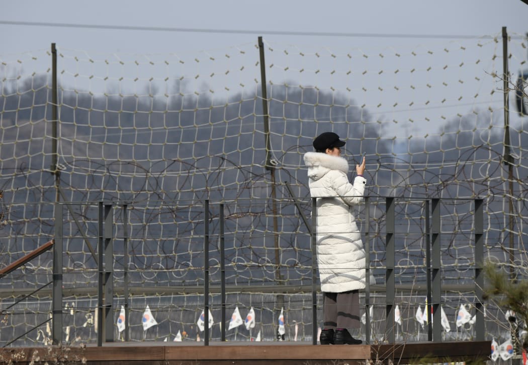 A visitor looks over a military fence on a viewing deck at Imjingak peace park, near the Demilitarised Zone (DMZ) dividing the two Koreas in Paju on 1 January 2020.