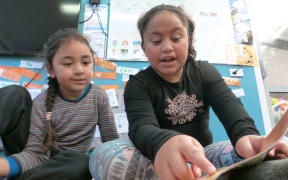 Hazel helps a younger pupil with reading. She would like to be a doctor when she's older.