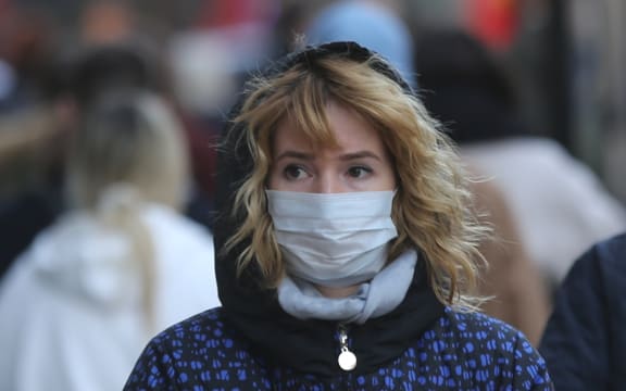 A woman in London wears a mask as a precaution against coronavirus.