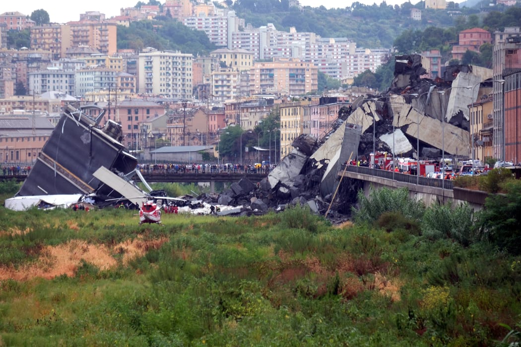 A picture taken on August 14, 2018 in Genoa shows a section of the Morandi motorway bridge that collapsed earlier injuring several people.