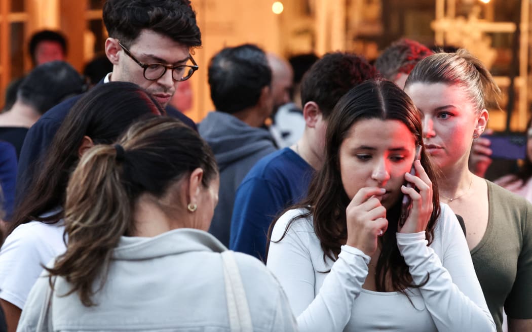 People react outside the Westfield Bondi Junction shopping mall after a stabbing incident in Sydney on April 13, 2024. Australian police on April 13 said they had received reports that "multiple people" were stabbed at a busy shopping centre in Sydney. (Photo by David GRAY / AFP)