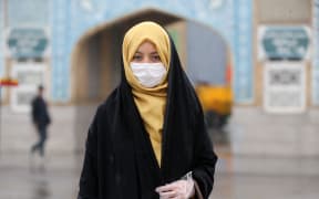 A woman wears a respiratory mask after deaths and new confirmed cases revealed from the coronavirus in Qom, Iran on February 25, 2020.