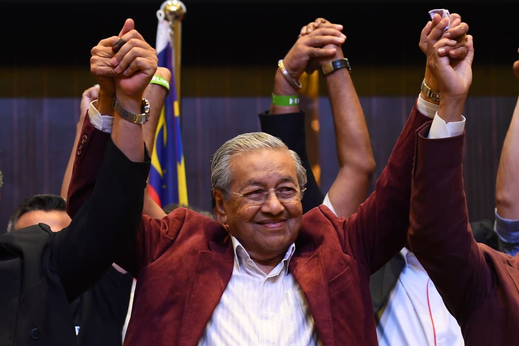 Former Malaysian prime minister and opposition candidate Mahathir Mohamad celebrates with other leaders of his coalition during a press conference in Kuala Lumpur.