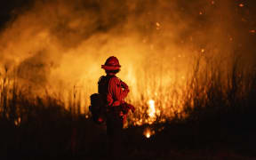A firefighter monitors the spread of the Auto Fire in Oxnard, North West of Los Angeles, California, on 13 January 2025.