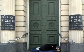 a homeless person sleep on the steps of a bank in new zealand in 2015.