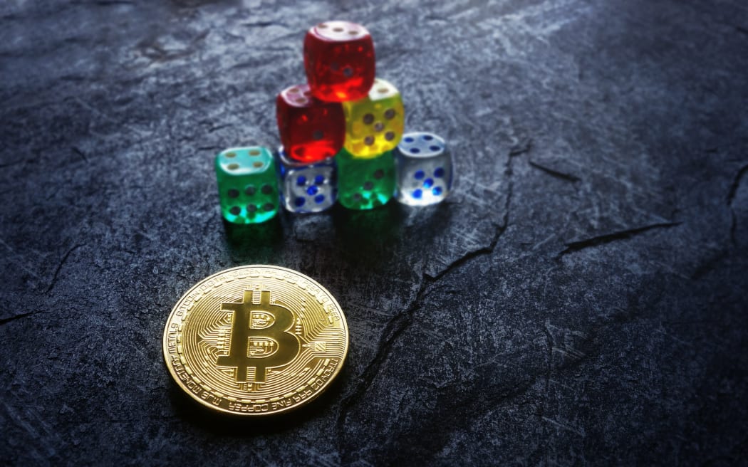 Gold bitcoin and stacked dice -- cryptocurrency investing and risk concept