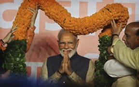 Indian Prime Minister Narendra Modi receives a giant floral garland from party leaders at their headquarters in New Delhi, India.