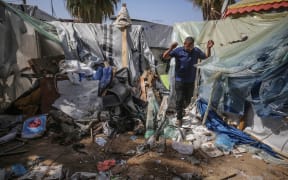 Palestinians check the damage at a makeshift camp for displaced people in front of the Al-Aqsa Martyrs Hospital in Deir al-Balah in the central Gaza Strip, after it was hit by an Israeli bombardment on 31 March, 2024.