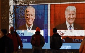 People watch a big screen displaying the live election results in Florida at Black Lives Matter plaza across from the White House on election day in Washington, DC on November 3, 2020.