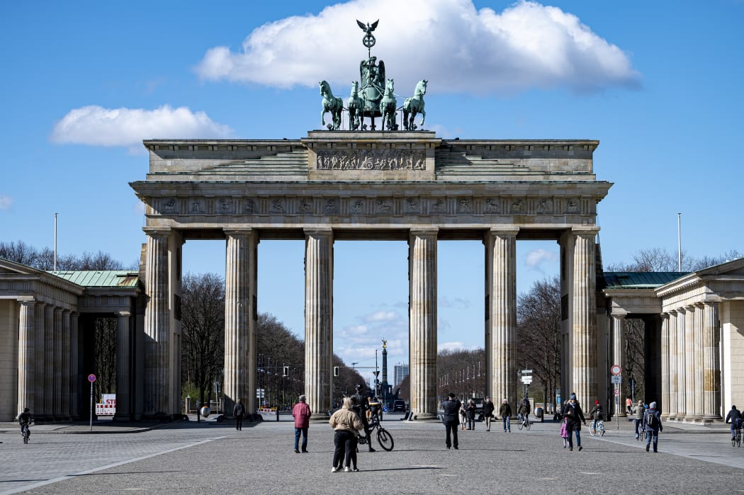 Passers-by stand on Pariser Platz in front of the Brandenburg Gate, 20 March.